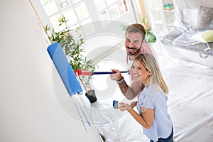Attractive young couple painting walls
