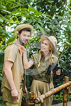 attractive young couple in safari suits with binoculars hiking together