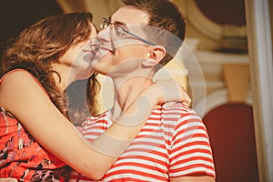 Attractive young couple smiling and kissing. Close up of happy couple in red clothes