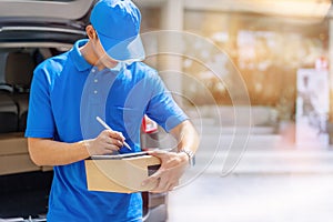Attractive young delivery man using tablet with carton box parcels. Delivery service courier concept