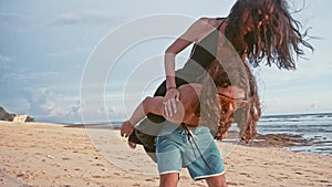 Attractive young and energetic couple having fun on the beach. Woman piggyback riding a man and laughing. Sea Summer