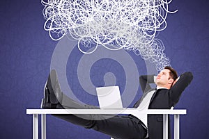 Attractive young european businessman daydreaming at office desktop with laptop and abstract scribble on purple background.