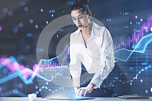 Attractive young european businessswoman leaning on desktop with abstract forex chart with index and grid on blurry office