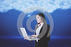 Attractive young european woman with laptop standing on blurry digital blue background with abstract cloud. Cloud computing, big