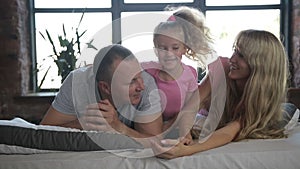 Attractive young family with daughter in bedroom