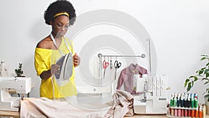 Attractive young fashion designer woman working at home studio.