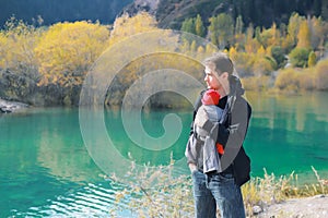 Attractive young father with her infant baby in sling outdoor. Babywearing concept