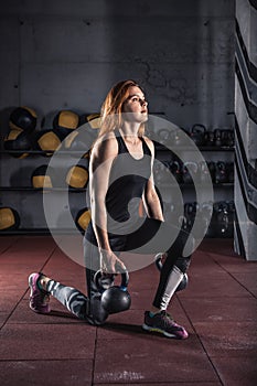 Attractive young female doing exercises with kettlebell.