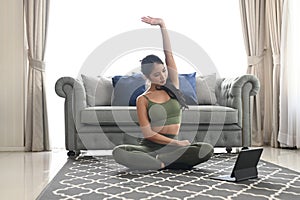 Attractive young female doing yoga stretching yoga online.e