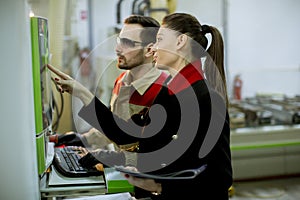 Attractive young female technician carrying out inspection at production department of plant