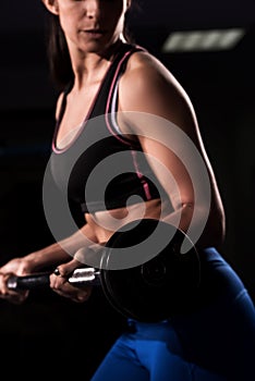 Attractive young fit sportswoman working out in gym lifting