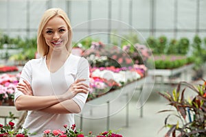 Attractive young gardener is working in greenhouse