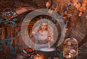 Attractive young girl with blond hair with an amazing lush wreath on her head in the forest is preparing a large