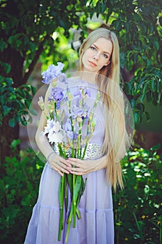 Atraktivní mladý blondýnka vlasy přírodní vonící modrý purpurová kosatec květiny na venku nabídka 