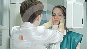 Attractive young girl doing examination of teeth by using panoramic and cephalometric X-Ray scanner photo