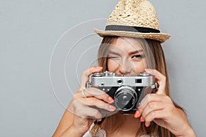 Attractive young girl in hat winking and holding camera