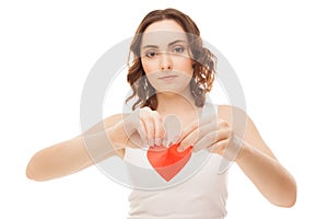 Attractive young girl holding broken paper red valentine heart