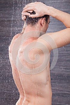 Attractive young guy is cleaning his body