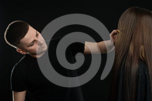 Attractive young Hair Dresser Combing Clients Hair In Salon photo