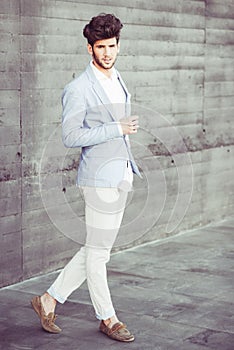 Attractive young handsome man, model of fashion in urban background