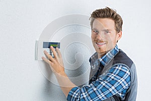 Attractive young handyman checks security alarm