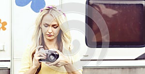Attractive, young hippie girl taking pictures outdoors at summer. Holiday, vacation, hobby concept.