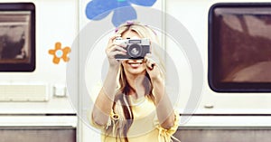 Attractive, young hippie girl taking pictures outdoors at summer. Holiday, vacation, hobby concept.