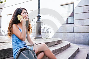 Attractive young indian female traveler resting and talking by phone