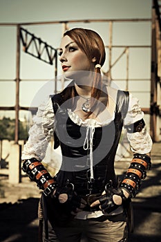 Attractive young l woman in leather corset posing outdoors.