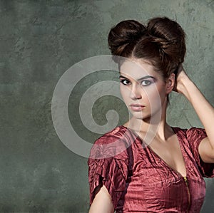 Attractive young lady in pink dress and funny styling posing on