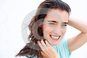 Attractive young lady smiling with hands in hair