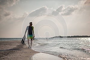 attractive young man on the beach with snorkeling equipment observes the coral world, free diver in the sea