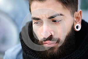 Attractive young man with beard and piercings