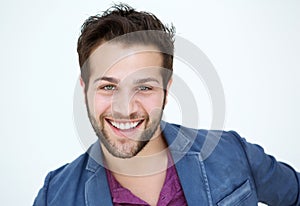 Attractive young man with beard smiling on white background