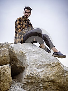 Attractive young man on big rock