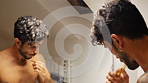 Attractive young man brushing teeth