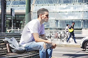 Attractive young man in city, sitting