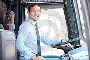 Attractive young man is driving a public transport