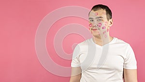 Attractive young man full of kiss marks on his face. photo