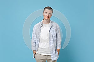 Attractive young man guy 20s in casual shirt posing isolated on pastel blue wall background studio portrait. People