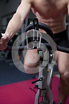 Attractive young man in gym on bike