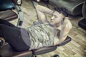 Attractive young man in gym exercising abs