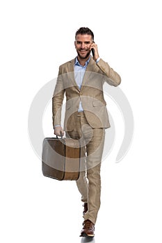 Attractive young man having a conversation on the phone and leaving town