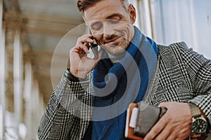 Attractive young man having phone conversation on the street