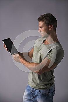 Attractive young man holding ebook reader or tablet PC