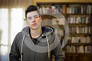 Attractive young man at home in front of bookcase