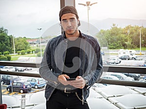 Attractive young man indoors wearing a denim jacket