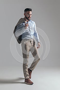 Attractive young man with jacket over shoulder looking to side