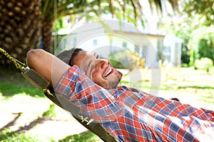 Attractive young man lying in hammock and smiling