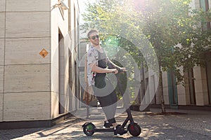 Attractive Young Man Riding Modern Kick Scooter At Cityscape Background. Contemporary Eco Transport